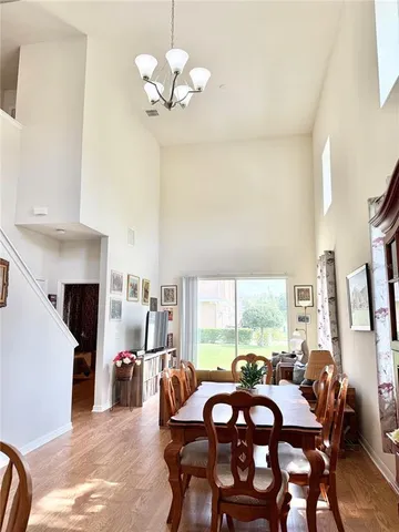a view of a dining room with furniture a chandelier and large windows