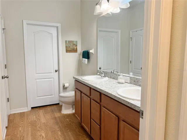 a bathroom with a granite countertop sink toilet and mirror