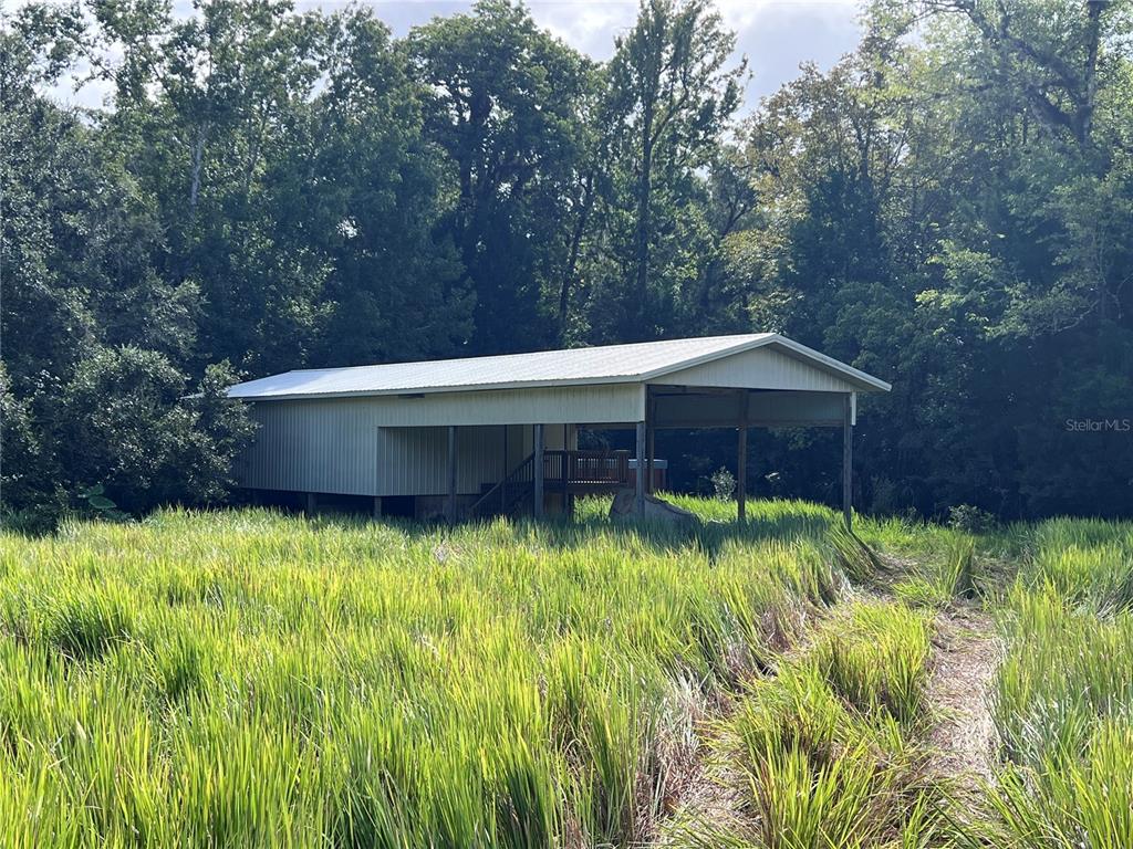 73 Alco Road Astor, FL 32102 - Photo 37 of 53 a backyard of a house with large trees and plants