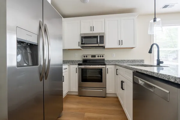 a kitchen with stainless steel appliances granite countertop a refrigerator and a sink