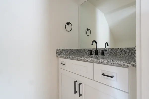 a bathroom with a granite countertop sink and a mirror