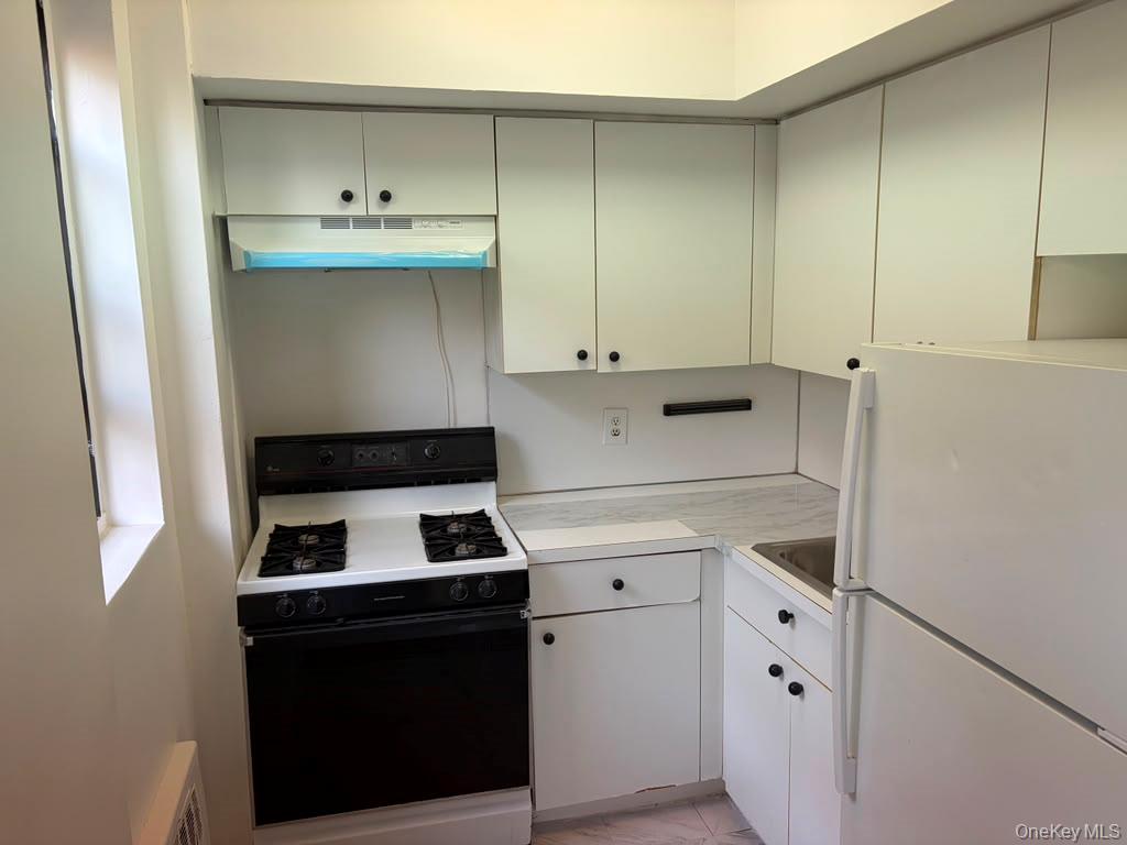 99-60 63rd Road, Unit 1H Queens, NY 11374 - Photo 10 of 11 a kitchen with cabinets and appliances