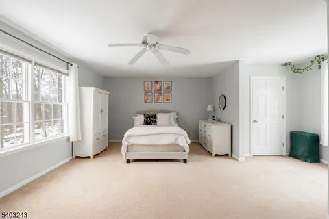 a spacious bedroom with a bed and a large window