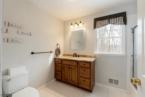 a bathroom with a toilet a sink and a window