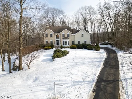 a view of a white house with a yard covered in snow