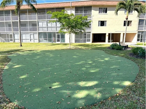 a view of a backyard with couches plants and large trees
