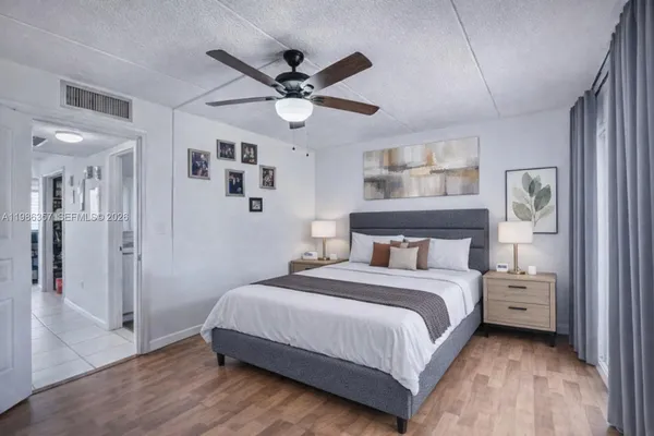 a bedroom with a large bed and a chandelier