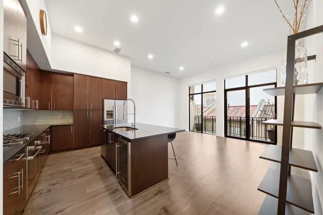 a kitchen with stainless steel appliances granite countertop a stove and a wooden floors