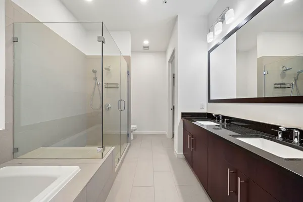 a bathroom with a sink a toilet and shower