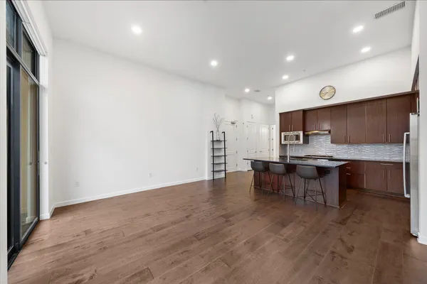a view of kitchen with kitchen island stainless steel appliances refrigerator stove microwave and cabinets