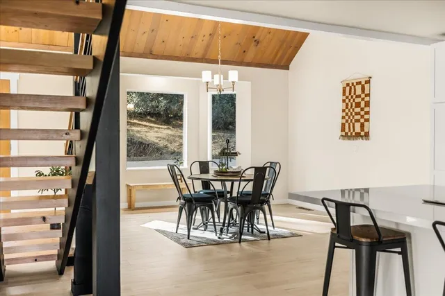 a kitchen with stainless steel appliances a table and chairs in it