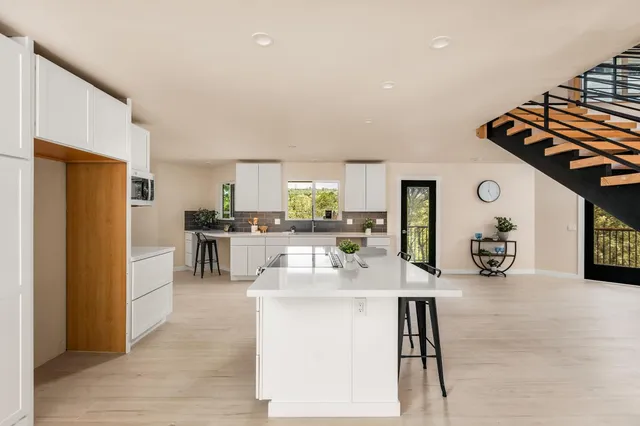 a kitchen with stainless steel appliances kitchen island granite countertop a refrigerator and a stove top oven