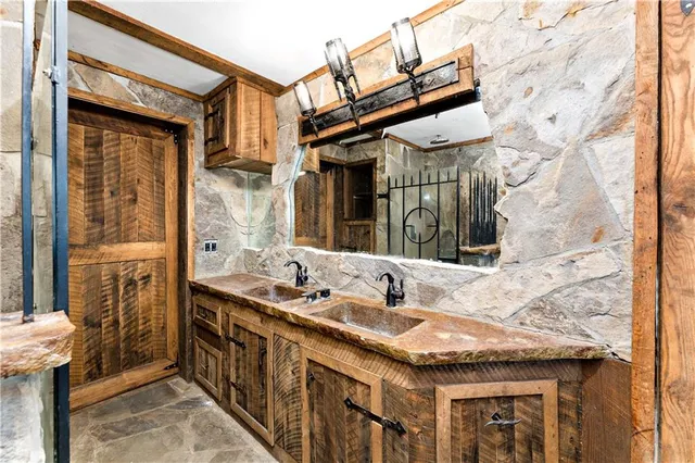 a bathroom with a granite countertop sink and a large mirror