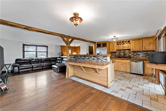 a kitchen with a stove a sink and white cabinets with wooden floor