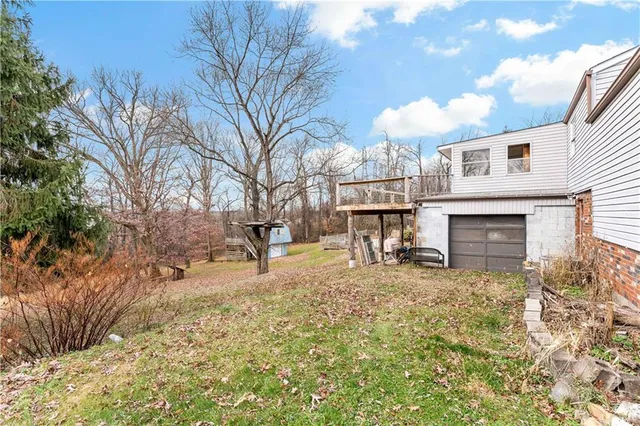 a view of a house with backyard and a tree