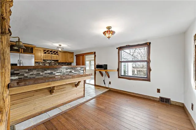 a view of a kitchen with a stove wooden floor and a living room