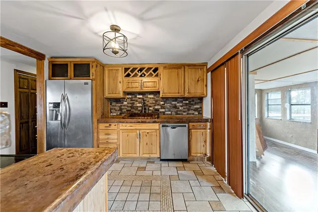 a kitchen with stainless steel appliances granite countertop a stove a refrigerator and a sink