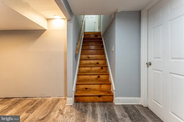 a view of a hallway with wooden floor and stairs