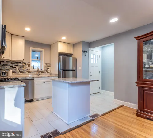 a kitchen with granite countertop a refrigerator and a stove top oven