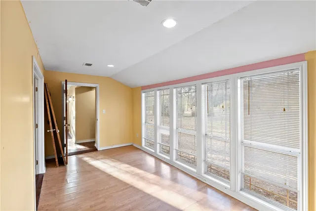 a living room with wooden floor and a chandelier
