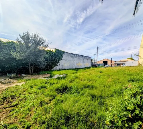 a view of a garden with a house in the background