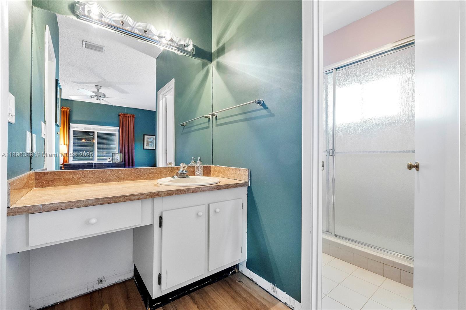 4764 South Hemingway Circle Margate, FL 33063 - Photo 14 of 30 a bathroom with a granite countertop sink a mirror and a shower