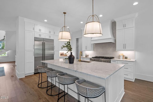 a kitchen with granite countertop a stove and white cabinets