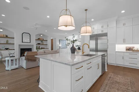 a dining room with wooden floor a chandelier a wooden table and chairs