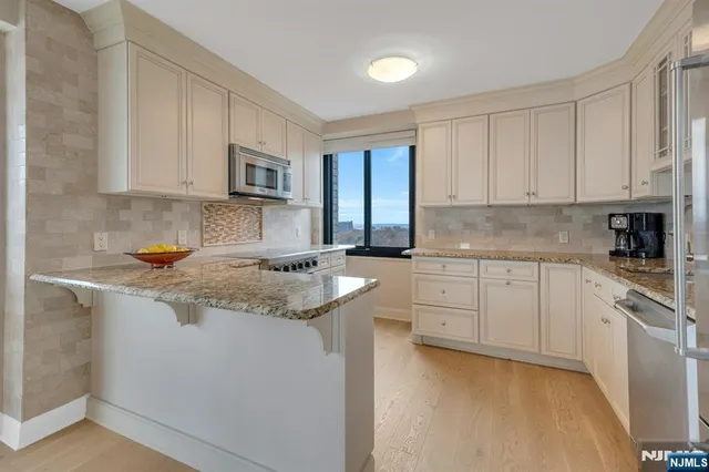 a kitchen with granite countertop white cabinets and white appliances