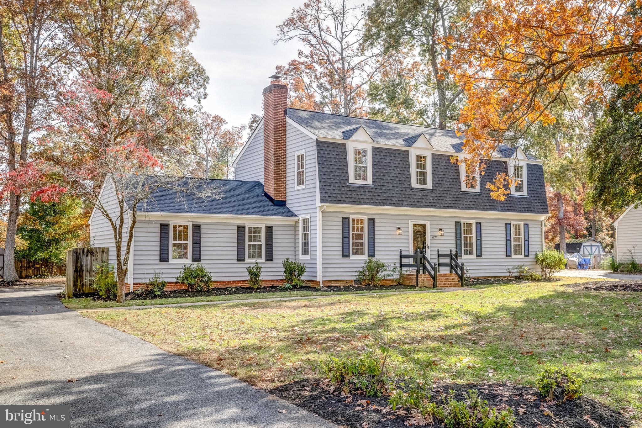 a front view of building with yard and trees around