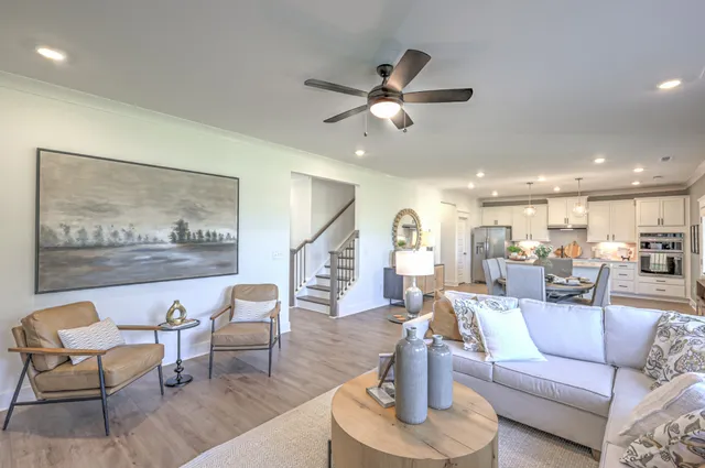 a living room with furniture and a view of kitchen