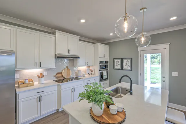 a kitchen with granite countertop white cabinets and stainless steel appliances