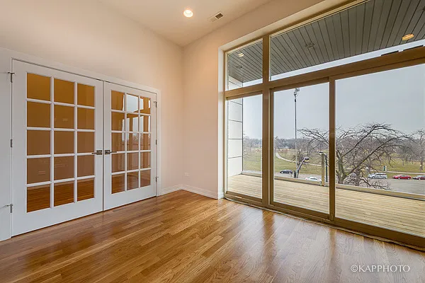a view of empty room with wooden floor and floor to ceiling window