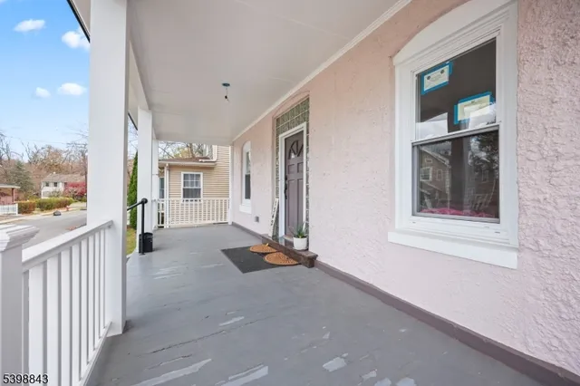 a view of a hallway with wooden floor and a bathroom