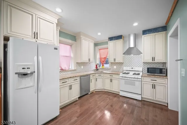 a kitchen with white cabinets and white appliances