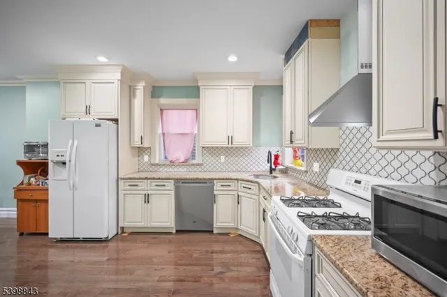 a kitchen with stainless steel appliances granite countertop a stove a sink dishwasher and a refrigerator