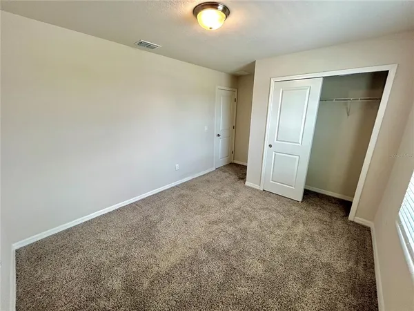 an empty room with closet and mirror