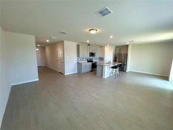a view of kitchen with refrigerator stove dining table and chairs