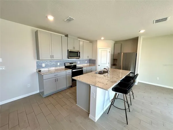 a kitchen with a sink cabinets and wooden floor