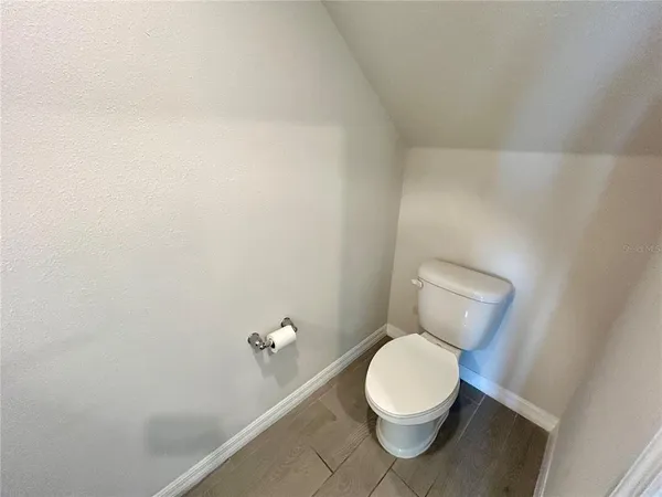 a white toilet sitting next to a white wall