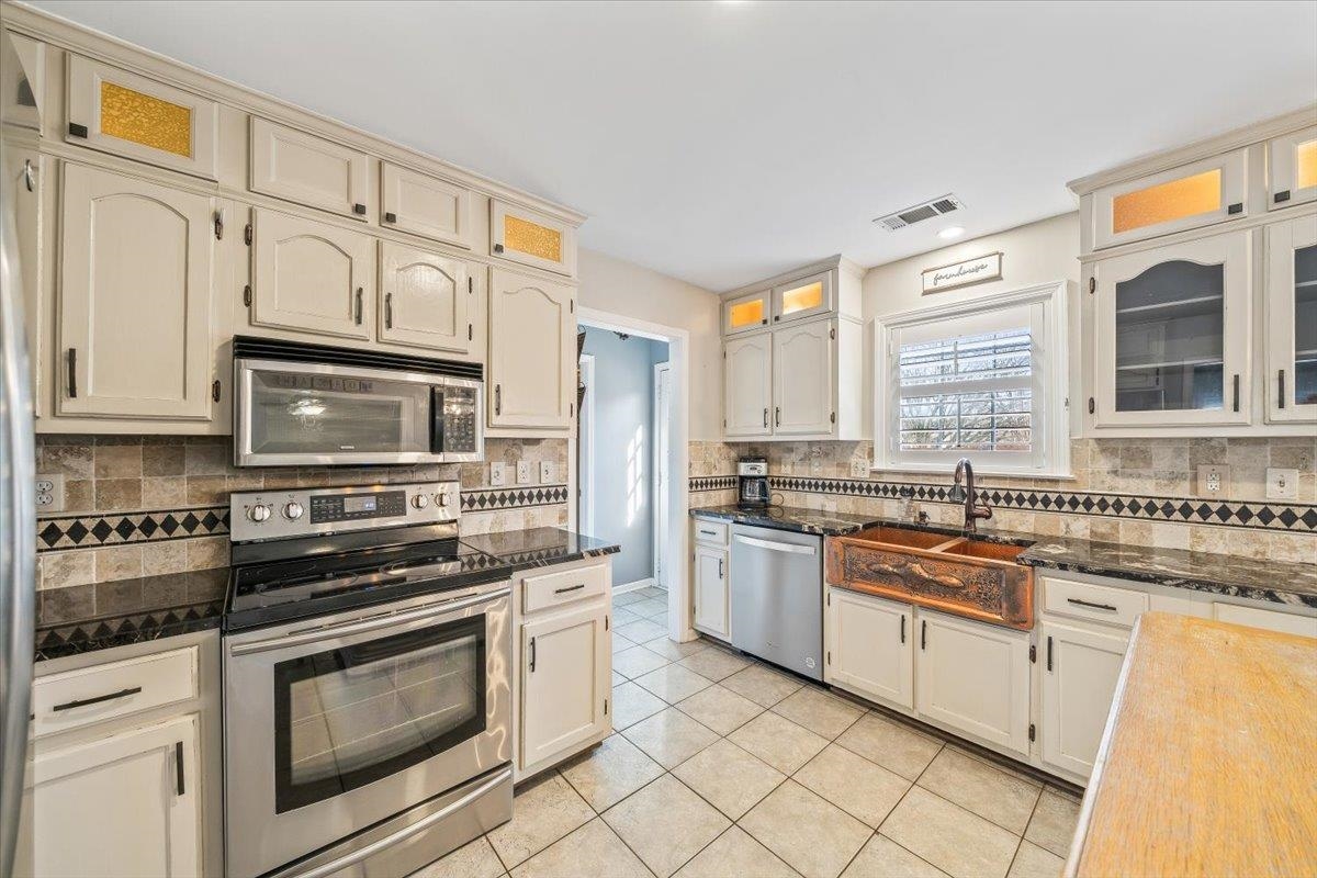 3204 Falling Star Cove Bartlett, TN 38134 - Photo 14 of 36 a kitchen with stainless steel appliances granite countertop a stove a sink and a microwave