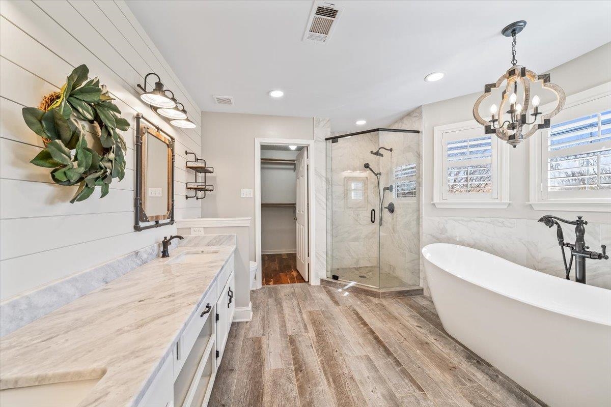 3204 Falling Star Cove Bartlett, TN 38134 - Photo 19 of 36 a spacious bathroom with a double vanity sink a large mirror and a bathtub