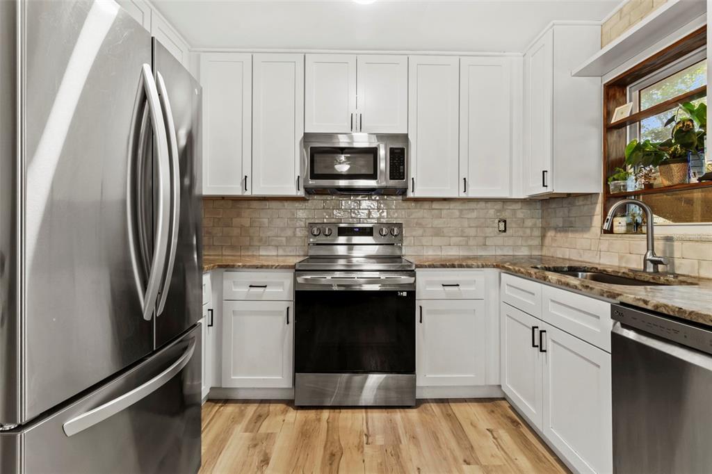 6221 Dalton Street Spring Hill, FL 34606 - Photo 21 of 40 a kitchen with stainless steel appliances a stove a sink and a refrigerator