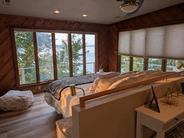 a bed sitting in a bedroom next to a large window