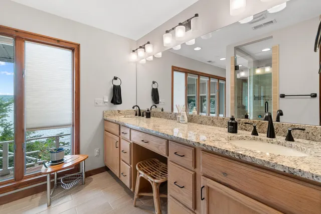 a bathroom with a granite countertop sink and a large mirror