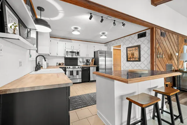 a kitchen with stainless steel appliances granite countertop a sink and a refrigerator