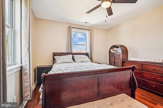 a bedroom with a bed and a dresser with the shoe rack