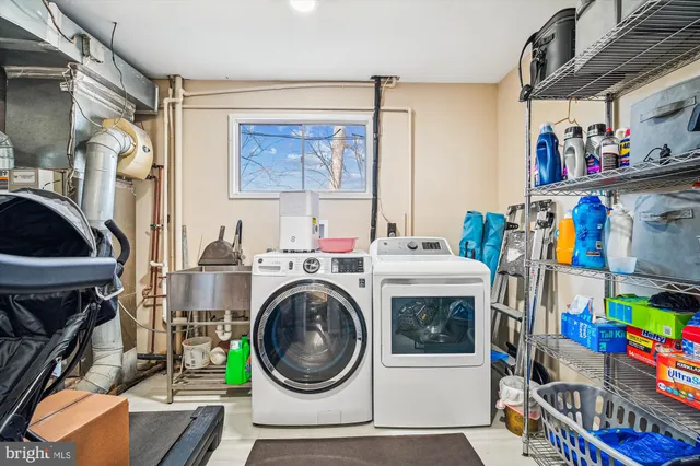 a utility room with dryer washer and a flat screen tv