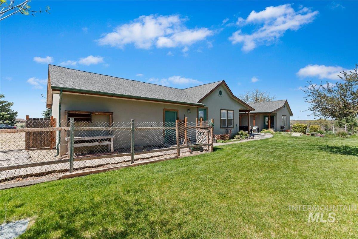 147 East Indian Crk Road Boise, ID 83716 - Photo 32 of 43 Expansive backyard featuring a manicured lawn, chain-link fencing, and mature trees