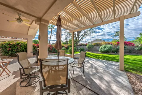 a view of a patio with a table chairs and a backyard